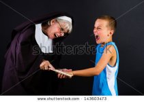 stock-photo-a-nun-punishing-a-young-child-by-hitting-him-on-the-knuckles-with-a-ruler-143603473.jpg