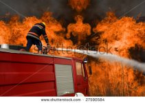 stock-photo-firefighter-on-a-firetruck-sitting-on-a-fire-hose-spraying-water-at-a-large-blaze-27.jpg